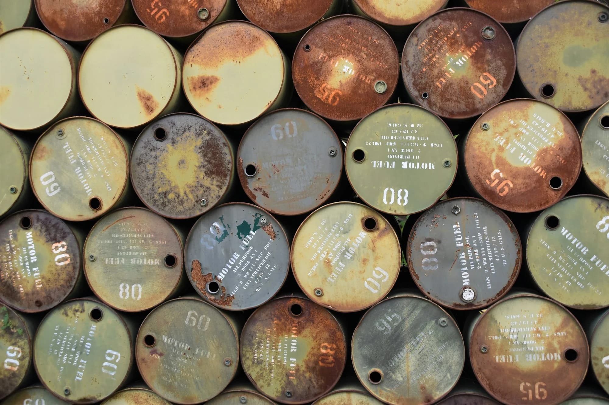 Rows of steel chemical drums seen from above